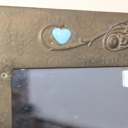 909 - An Art Nouveau hammered brass-framed wall mirror, with heart-shaped blue enamel bosses, 57cm x 51cm ... 