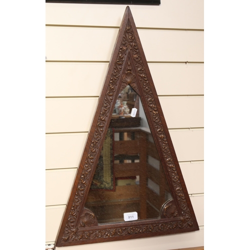 911 - A 1920s carved oak triangular framed wall mirror, length 65cm