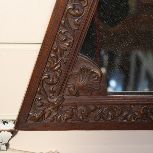 911 - A 1920s carved oak triangular framed wall mirror, length 65cm