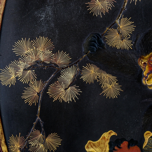 1101 - A Japanese gilded and lacquered wall panel, depicting monkeys and fruit, in original painted red lac... 