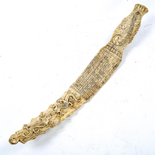 1120 - A 19th century Indonesian relief carved bone calendar, decorated with reptiles, length 42cm