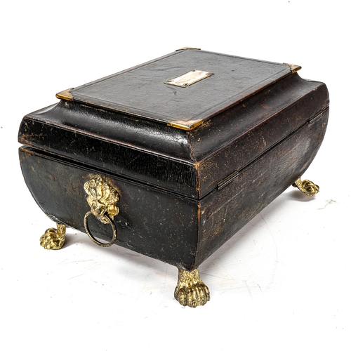 1121 - A Regency leather-covered sarcophagus-shaped sewing box, with brass mounts and lion paw feet, origin... 