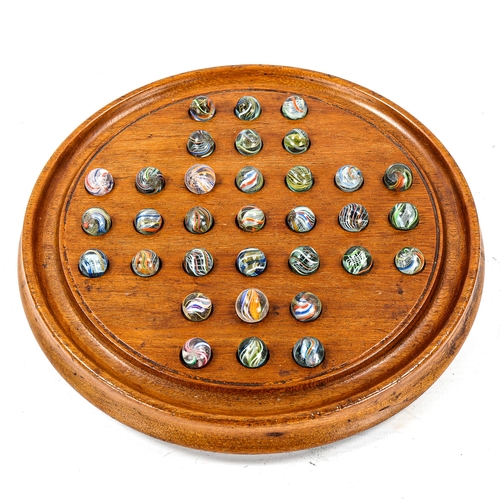 1122 - A mahogany Solitaire board, with Victorian marbles, board diameter 23cm