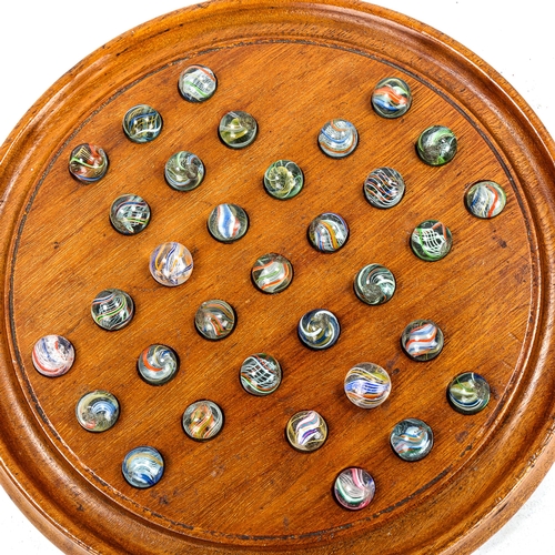 1122 - A mahogany Solitaire board, with Victorian marbles, board diameter 23cm