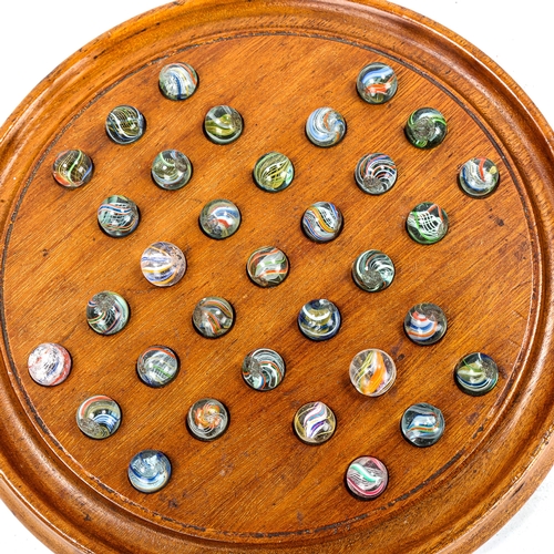 1122 - A mahogany Solitaire board, with Victorian marbles, board diameter 23cm