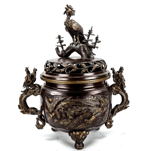1129 - A large Chinese patinated bronze incense burner, with exotic bird finial, parcel gilt relief cast pa... 