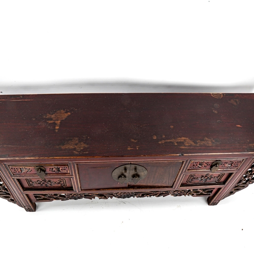 1134 - A Chinese stained wood altar table of small size, with 4 small carved drawers and central cupboard f... 