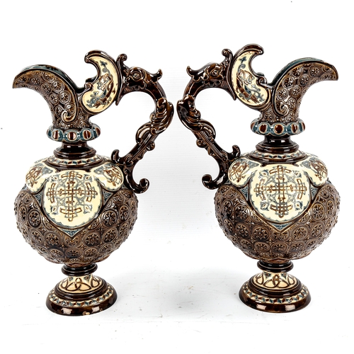 1142 - A pair of 19th century Hungarian pottery ewers, with relief moulded decoration, height 34cm