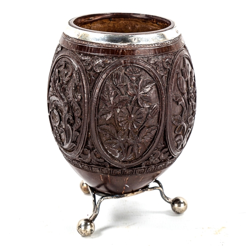 1158 - A 19th century relief carved coconut vase, with botanical decorated panels and unmarked white metal ... 