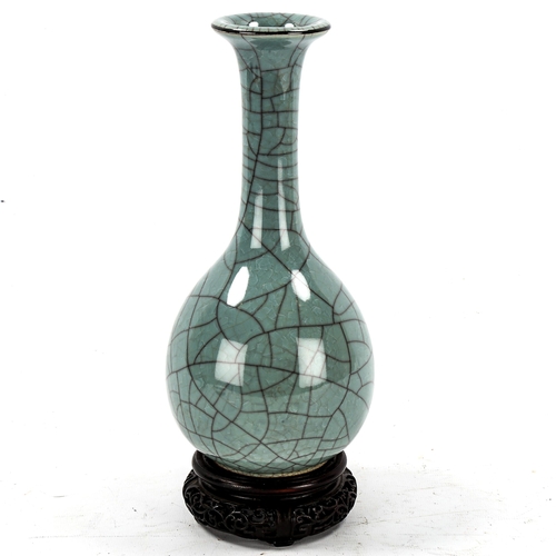 1224 - A Chinese celadon crackle glaze narrow-neck vase, impressed marks under base, hardwood stand, height... 