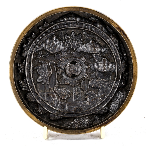 1243 - A Japanese bronze hand mirror with relief cast panel, signed Ama-Shimo circa 1680, diameter 12cm