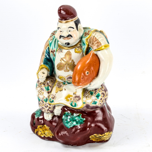 1245 - A Chinese porcelain figure of a man holding a carp, early 20th century, height 20cm