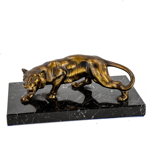 1257 - A gilded spelter prowling tiger sculpture, on black marble base, length 22cm