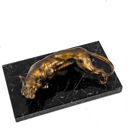 1257 - A gilded spelter prowling tiger sculpture, on black marble base, length 22cm