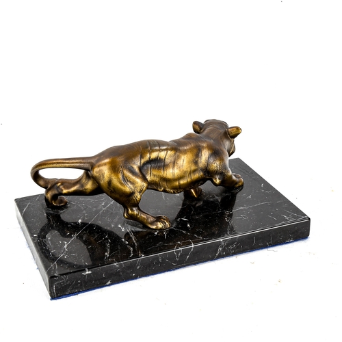 1257 - A gilded spelter prowling tiger sculpture, on black marble base, length 22cm