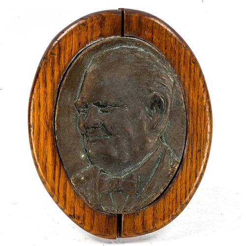 1266 - A relief cast bronze plaque, depicting Winston Churchill, in oak strut mount, overall height 26cm