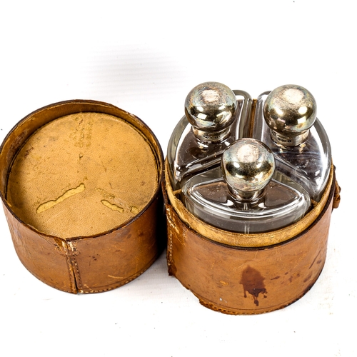 1268 - A leather-cased set of 3 silver-topped glass bottles, case height 14cm, diameter 9.5cm (A/F)