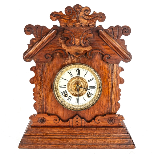 73 - An American oak-cased gingerbread 8-day mantel clock, by Ansonia Clock Company, cream enamel dial wi... 