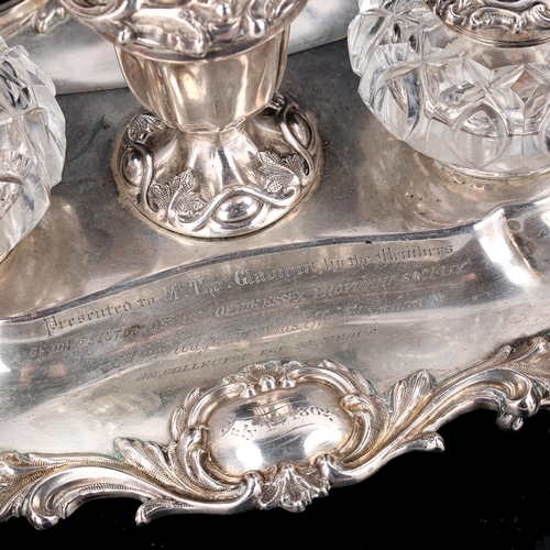 120 - A Victorian silver desk ink stand, oval form with cast foliate rim, scrolled feet and silver-mounted... 