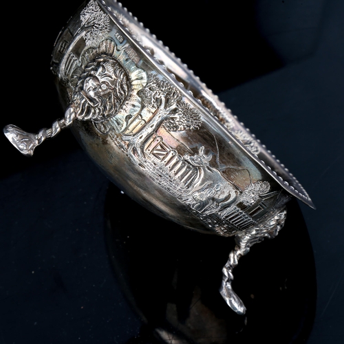 187 - An Edwardian Irish silver bowl, relief embossed farmyard scenes with lion mask and paw feet, by Samu... 