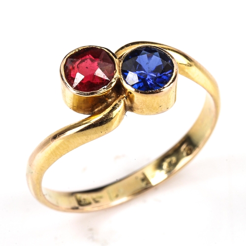 275 - An unmarked gold gem set crossover ring, set with red and blue stones, setting height 8.5mm, size N,... 