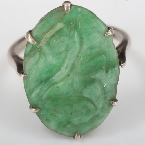 396 - A Chinese silver and carved jade oval panel ring, setting height 20.8mm, size J, 2.8g