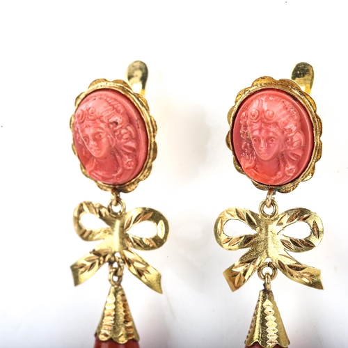 405 - A pair of faux composition coral drop earrings, unmarked gold settings with relief moulded female bu... 