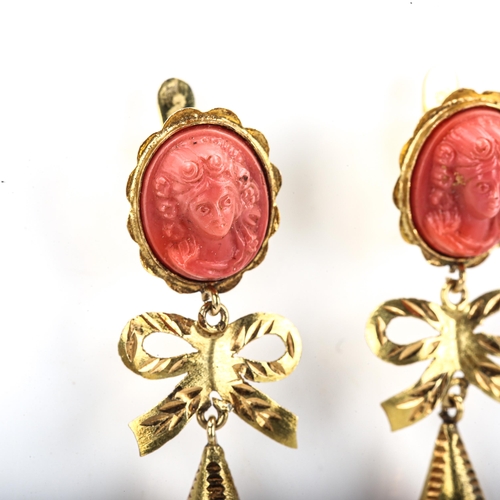 405 - A pair of faux composition coral drop earrings, unmarked gold settings with relief moulded female bu... 