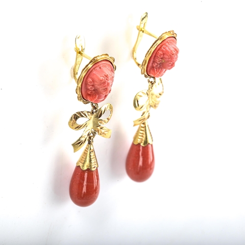 405 - A pair of faux composition coral drop earrings, unmarked gold settings with relief moulded female bu... 