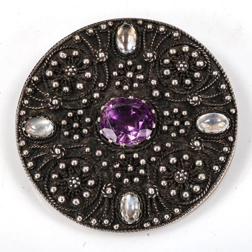 412 - An Arts and Crafts sterling silver amethyst and moonstone circular brooch, cannetille decoration, br... 