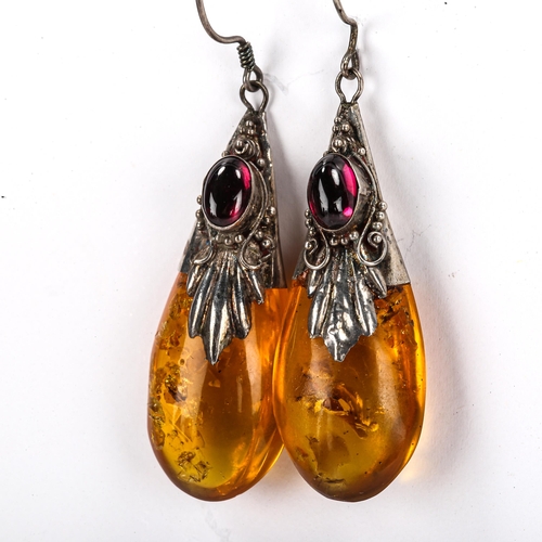 453 - A pair of Continental amber pendant earrings, unmarked silver settings with cabochon garnet and shep... 