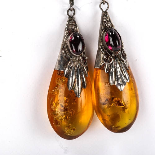 453 - A pair of Continental amber pendant earrings, unmarked silver settings with cabochon garnet and shep... 