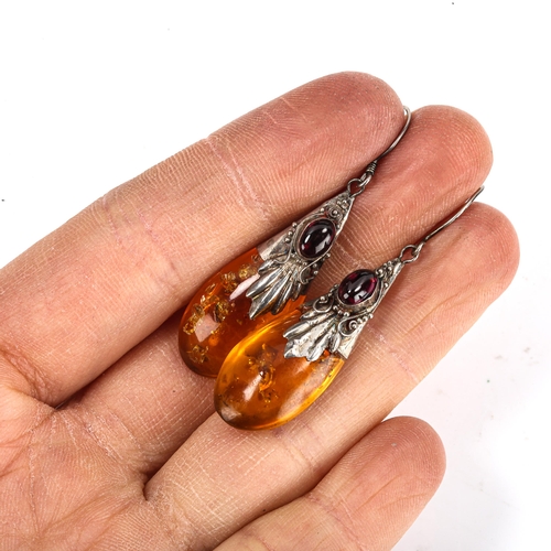 453 - A pair of Continental amber pendant earrings, unmarked silver settings with cabochon garnet and shep... 