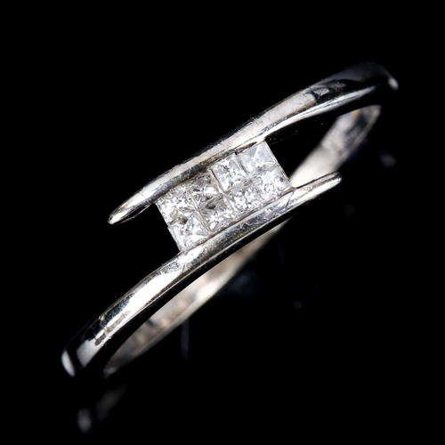 468 - A modern 9ct white gold diamond crossover ring set with Princess-cut diamonds, total diamond content... 