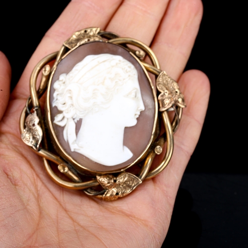 527 - A Victorian shell cameo brooch, depicting female profile, unmarked yellow metal ivy design frame, ov... 