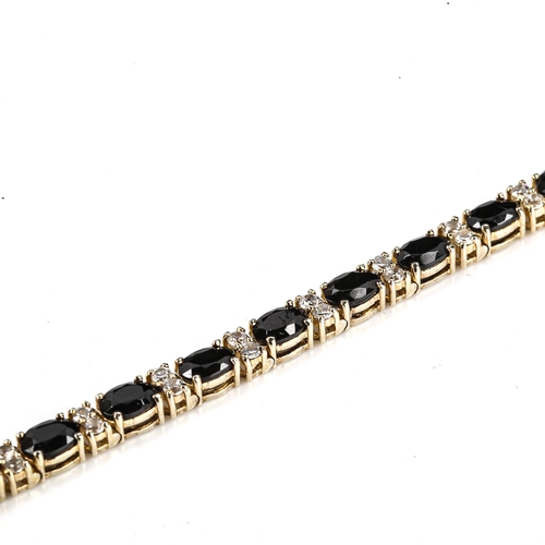 535 - A modern silver-gilt blue and white sapphire tennis line bracelet, bracelet length 18cm, 11.7g