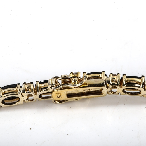 535 - A modern silver-gilt blue and white sapphire tennis line bracelet, bracelet length 18cm, 11.7g