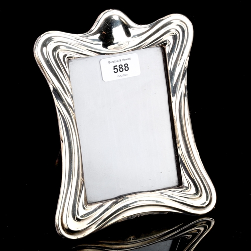 588 - An Edwardian Art Nouveau silver-fronted strut photo frame, by E Mander & Son, hallmarks Birmingham 1... 