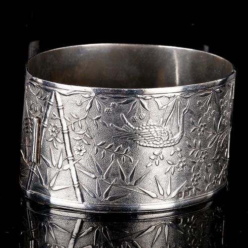 240 - A large early 20th century silver Aesthetic Movement hinged bangle, engraved chinoiserie decoration,... 