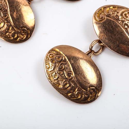 261 - A pair of early 20th century 9ct rose gold oval panel cufflinks, engraved foliate decoration, hallma... 