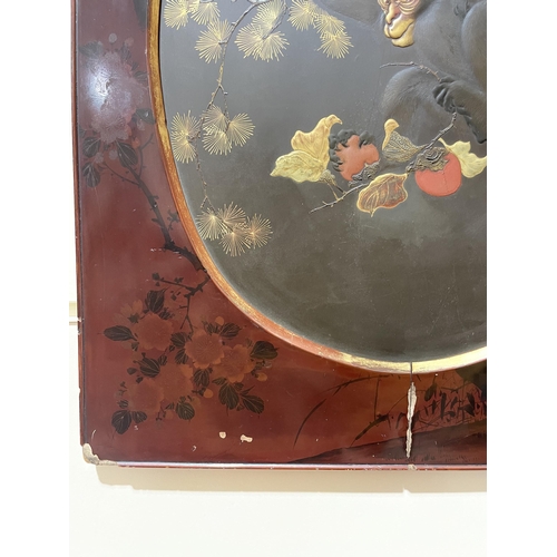 1101 - A Japanese gilded and lacquered wall panel, depicting monkeys and fruit, in original painted red lac... 