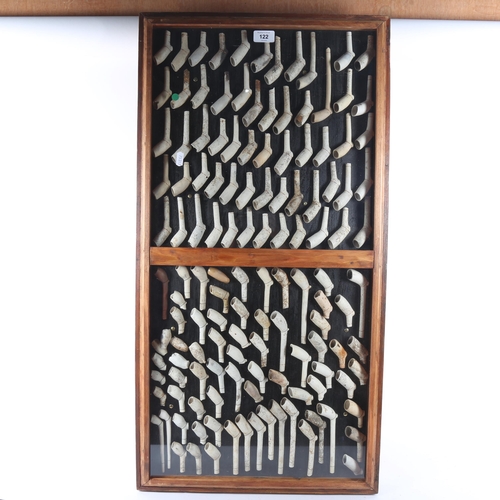 122 - A cabinet display of Antique clay pipes, 90cm x 46cm