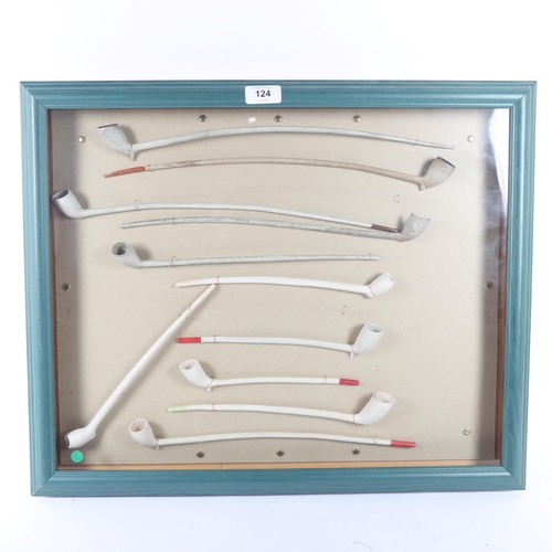 124 - A framed display of Antique long clay pipes, 46cm x 56cm