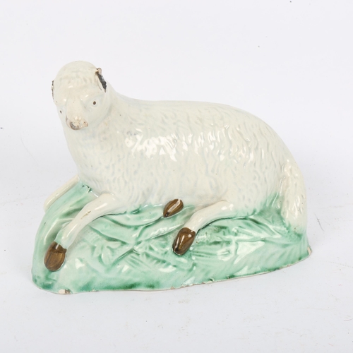 130 - A late 18th century Ralph Wood type polychrome pottery figure of a recumbent ewe, length 16cm