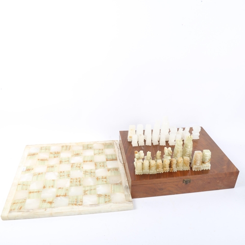 149 - A set of green and white onyx chessmen, with matching onyx chess board, 36cm x 36cm, King height 9cm... 