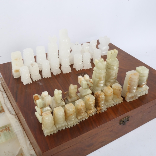 149 - A set of green and white onyx chessmen, with matching onyx chess board, 36cm x 36cm, King height 9cm... 