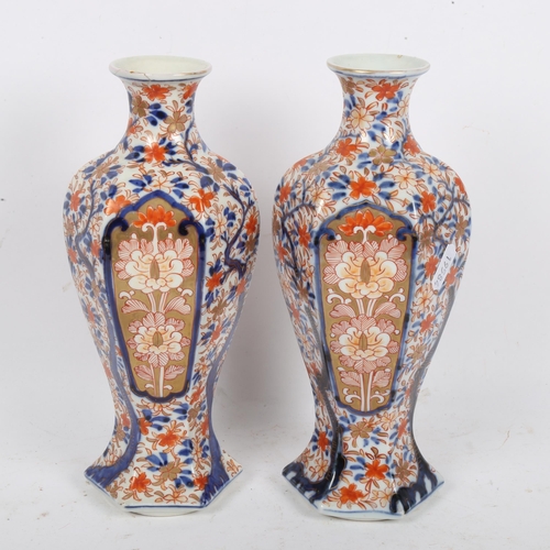 209 - A pair of Japanese Imari style hexagonal baluster vases, height 25cm (repaired chip on 1 rim)