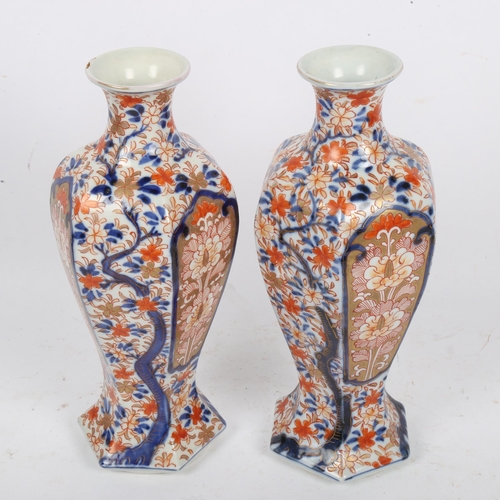 209 - A pair of Japanese Imari style hexagonal baluster vases, height 25cm (repaired chip on 1 rim)