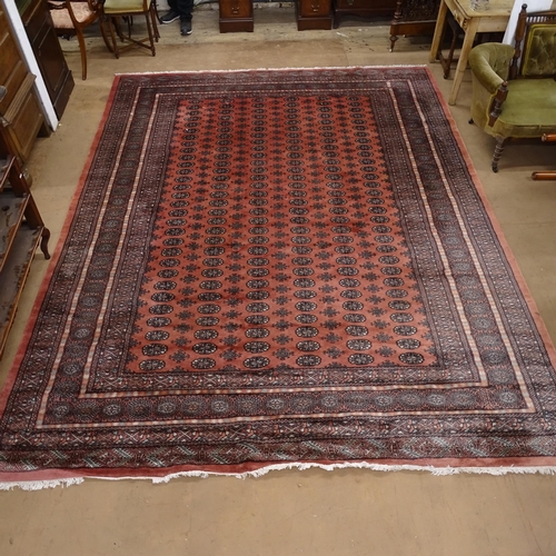 2070 - A large salmon ground Afghan Tekke design carpet, 370cm x 284cm