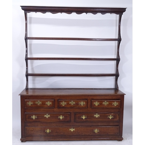 2075 - An 18th century oak dresser with open plate rack, the base fitted with 3 short and 3 long drawers, L... 